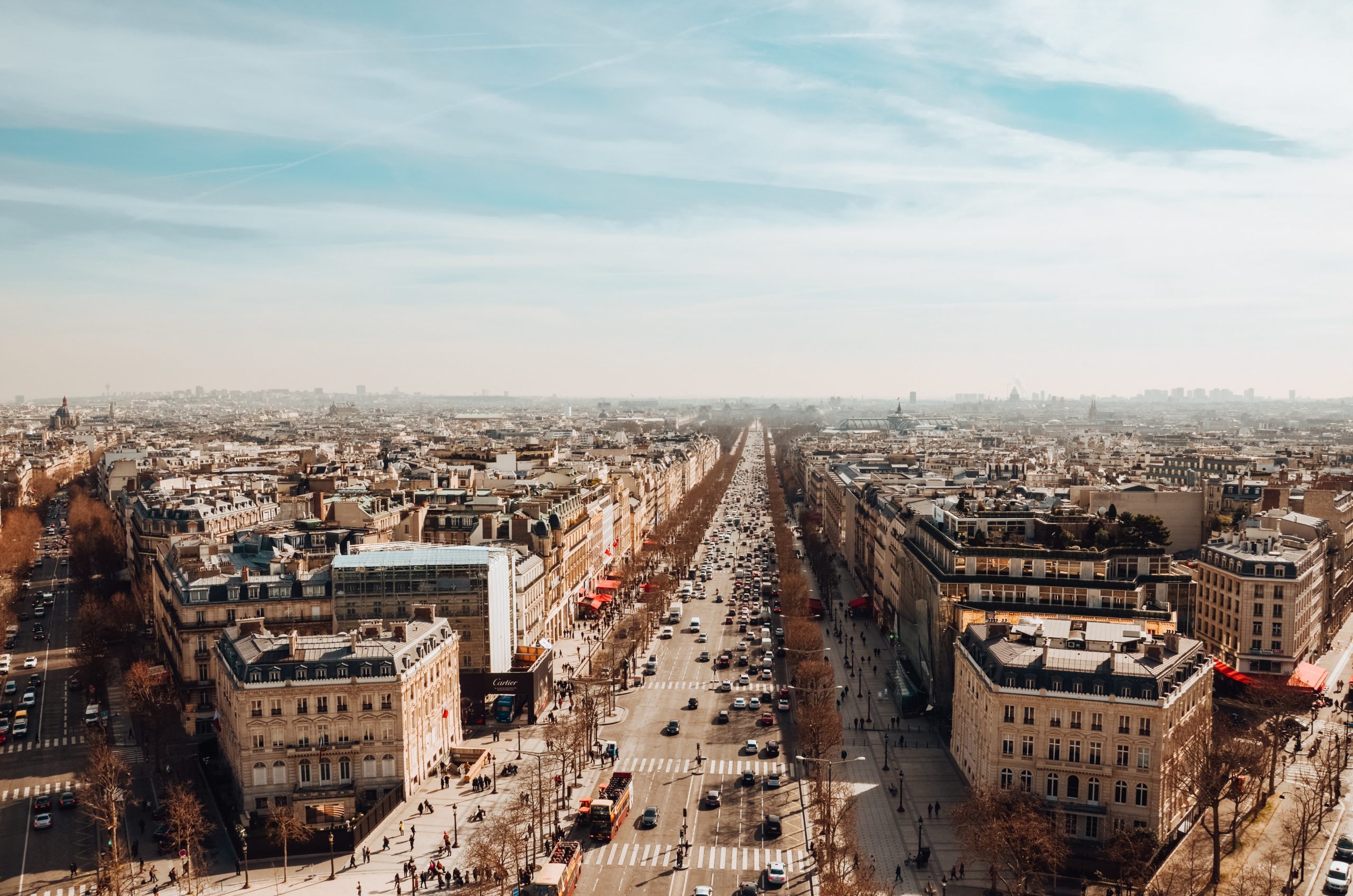 A high angle view of The Avenue des Champs-Elysees under a cloudy sky and sunlight in Paris