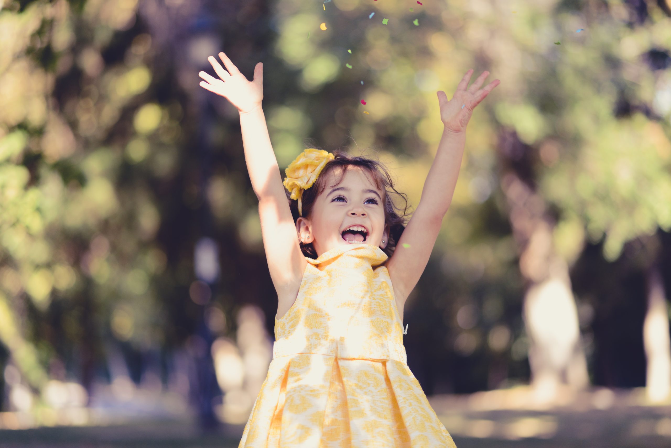 Portrait of a little girl running and playing in the park wearing a beautiful dress