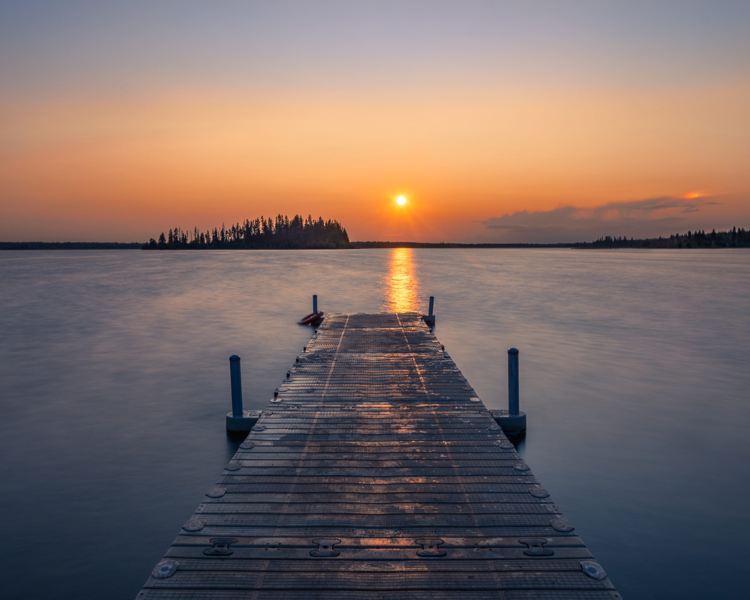 An empty wooden dock  in a lake during a breathtaking sunset- a cool background